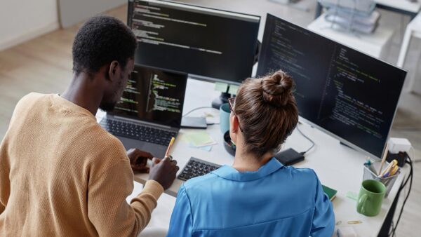 Photo of two students working together on a computer programming project