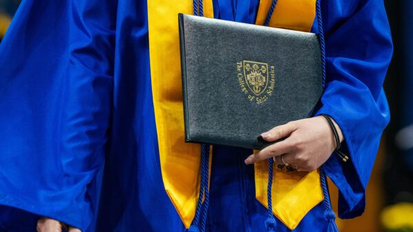 Photo of a St. Scholastica graduate with their diploma