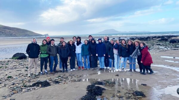 St. Scholastica study abroad students pose together on a cold beach.