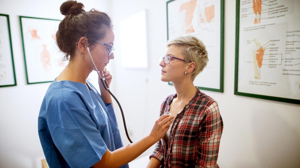 Nurse practitioner examines female student at St. Scholastica's Student Health Services