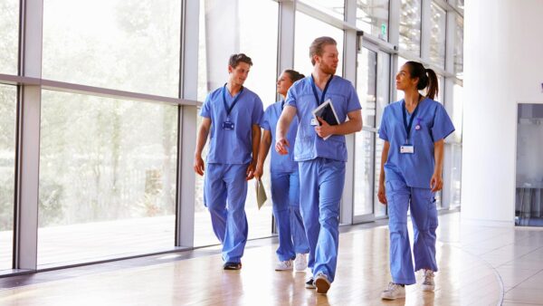 A group of St. Scholastica nurses walk through a hallway together.