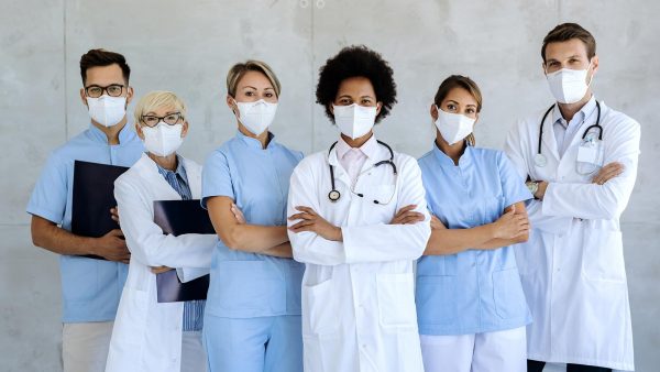 Healthcare workers standing in a medical facility with masks.