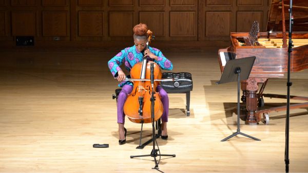 Ifetayo Ali-Landing plays the cello on the stage of Mitchell Auditorium.