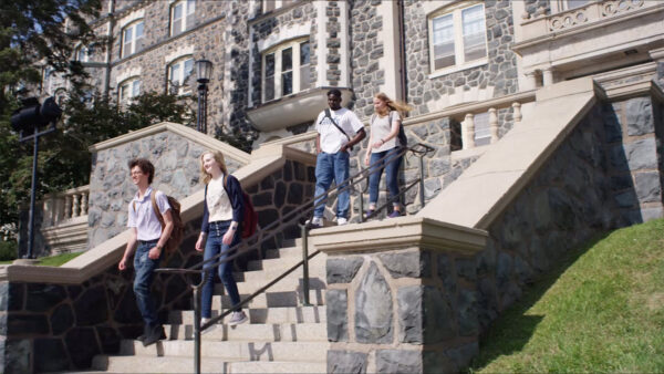 St. Scholastica campus video poster — students coming out of Tower Hall.