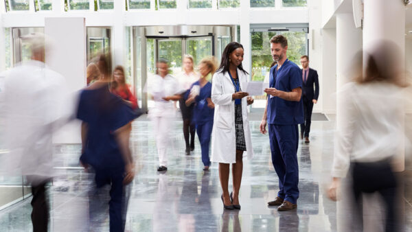 Healthcare professionals walking in a hallway of a medical facility.