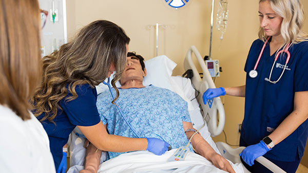 St. Scholastica Nursing student doing an abdominal check in the Nursing Simulation Lab.