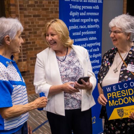 President McDonald talking with two individuals during her welcome reception.