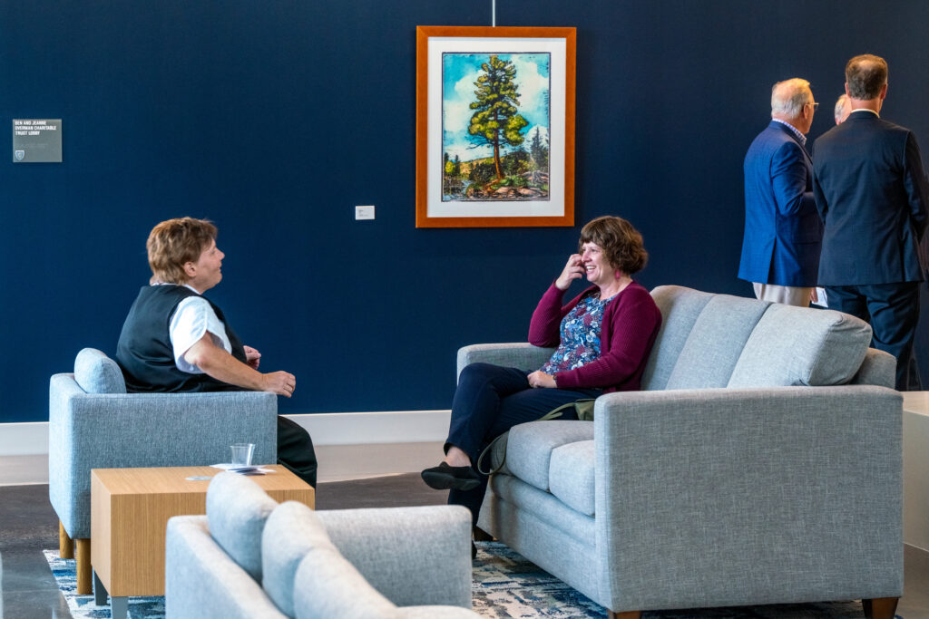 Two individuals sit on couches in the Student Center and have a conversation