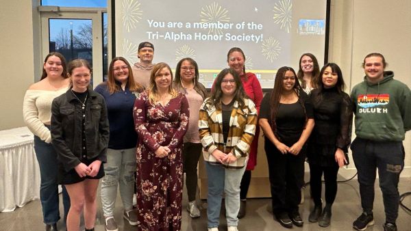 12 Tri-Alpha inductees standing together smiling.