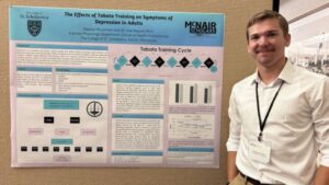 Weston Stoschein stands in front of his research poster.